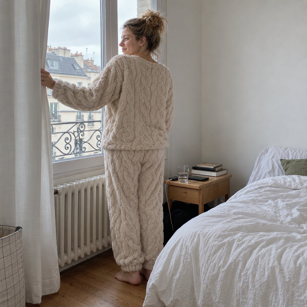 Pyjama pilou torsadé beige, femme debout à la fenêtre